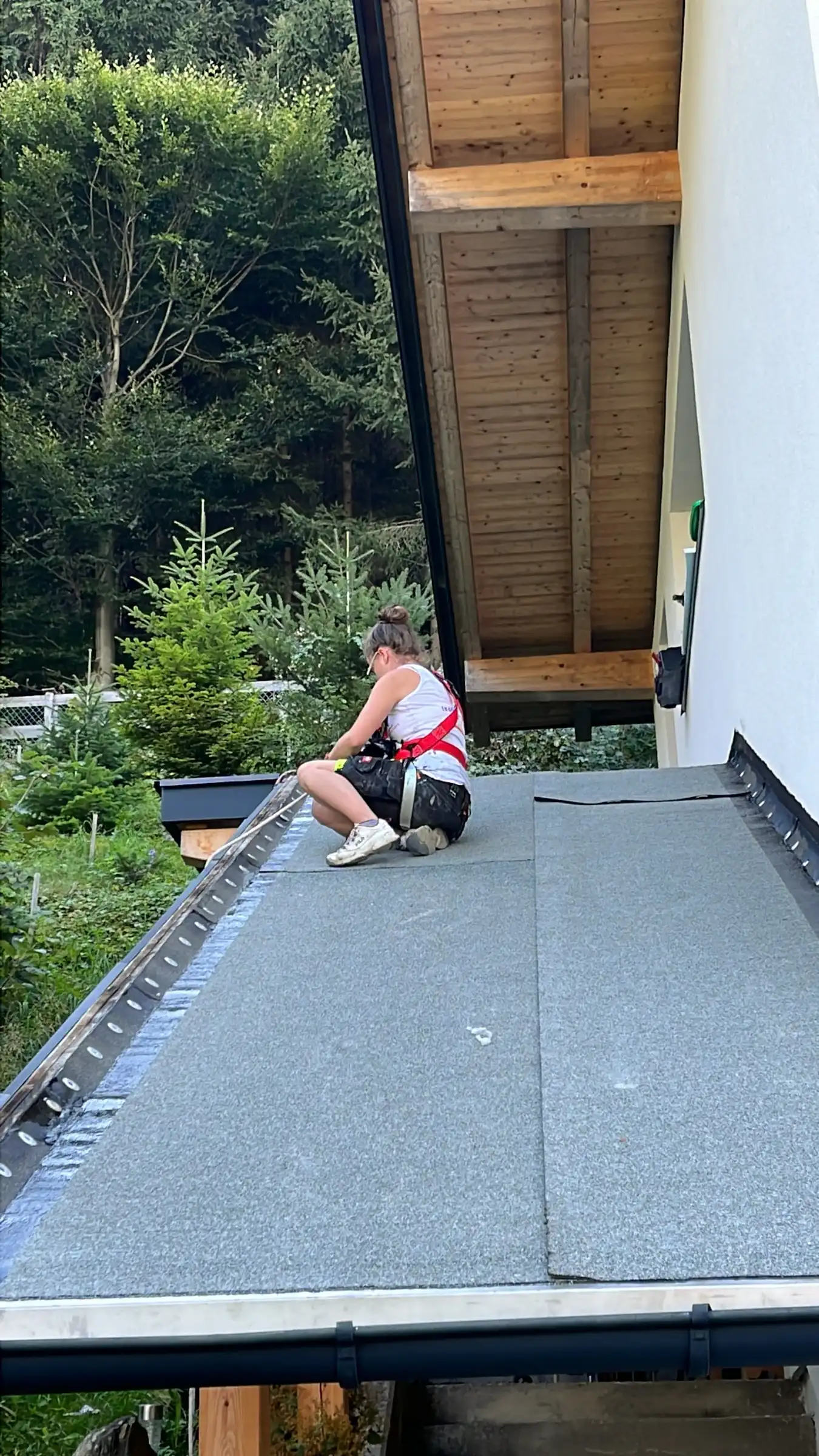 Schwarzdeckerin bei der Abdichtung eines Flachdachs